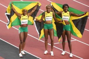 Elaine Thompson-Herah (centre), Shelly-Ann Fraser-Pryce (left), and Shericka Jackson celebrate their clean sweep of the women's 100-metre final at the Tokyo Olympics.